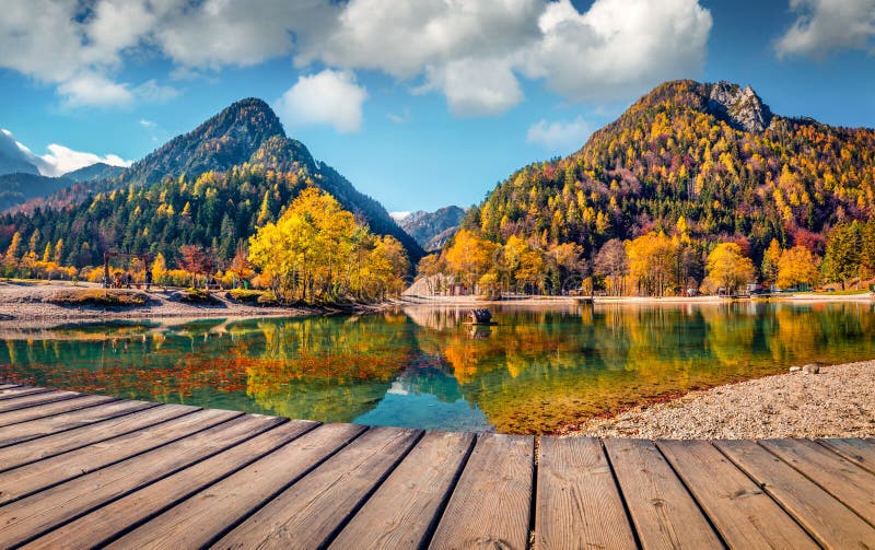 Bright autumn day on the shore of the Jasna lake. Stunning summer scene of Julian Alps, Gozd Martuljek location, Slovenia, Europe.