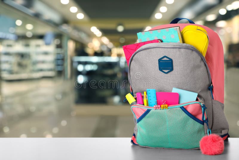 Bright Backpack with School Stationery on Table in Shopping Mall Stock