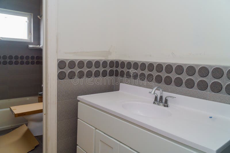 Bright Bathroom With Structural Tiles And Wooden Vanity Cabinet