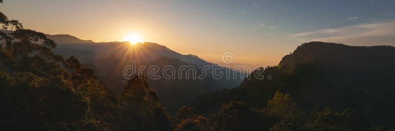 Bright beautiful landscape, sunset sky and rays of the sun over mountains. Panorama banner format. Bright beautiful landscape, sunset sky and rays of the sun