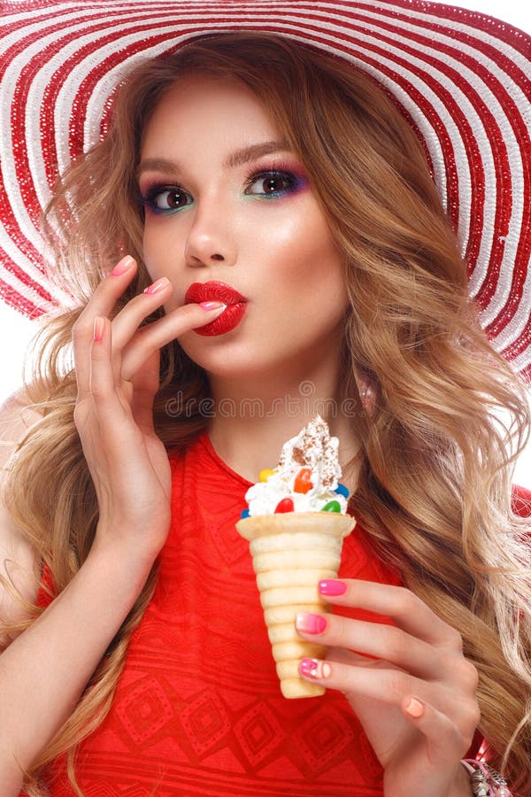 Bright cheerful girl in summer hat, colorful make-up, curls, pink manicure and ice cream in the hands. Beauty face.