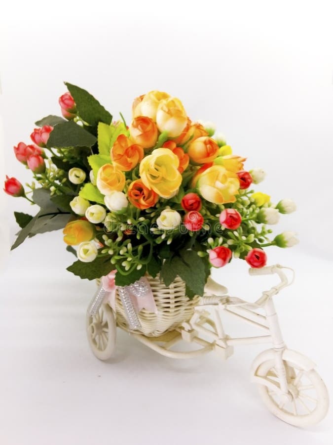 Bright and colorful plastic flower bouquet are in the white bicycle vase, isolated on white background and clipping path. stock photography Bright and colorful plastic flower bouquet are in the white bicycle vase, isolated on white background and clipping path. stock photography