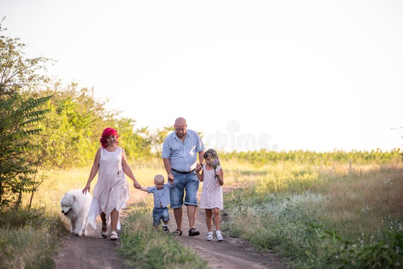 Bright Diversity Family Walks On The Paths In Field With Samoyed Dog Traveling With Pets Stock Bright Diversity Family Walks On The Paths In Field With Samoyed Dog Traveling With Pets Stock