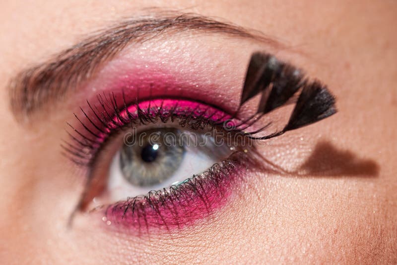 Bright fashionable eye with feathers on eyelashes stock photography