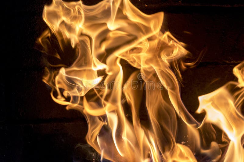 Bright fire in the fireplace close-up. red-yellow fire background. The tongues of flame resemble a tiger.