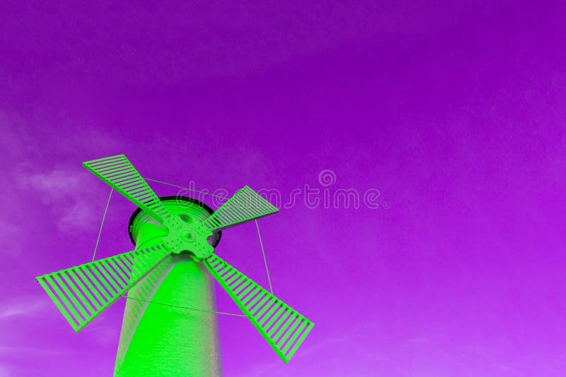 A bright green windmill against a purple sky, a concept of creativity and surreal architecture