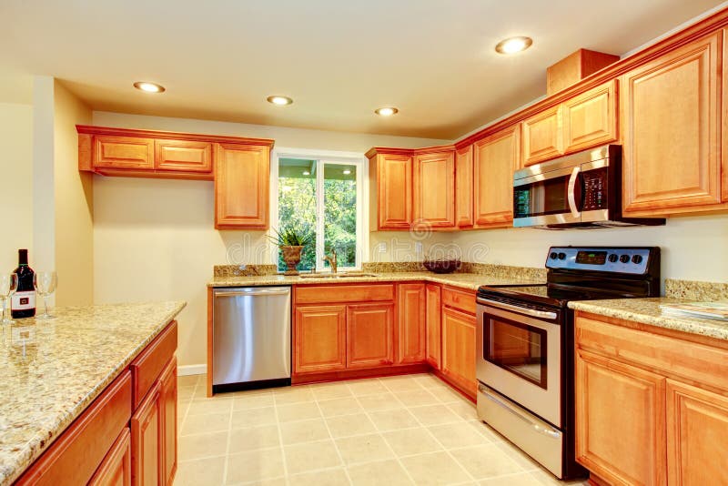 Bright Kitchen Room with Light Brown Cabinets and Steel Appliances ...