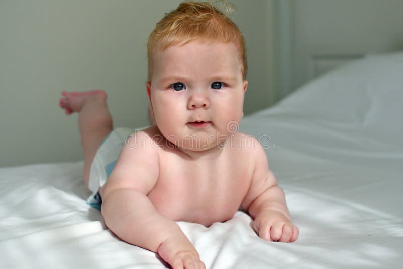 Bright Morning Portrait Of A Cute Baby Lying Down On A Bed Stock Photo