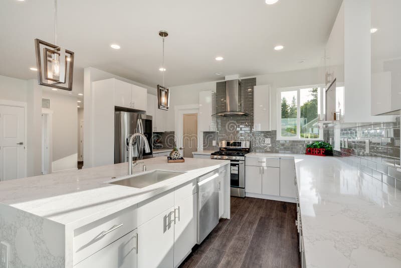 Bright and Neutral Kitchen with a Large Marble Waterfall Island Stock