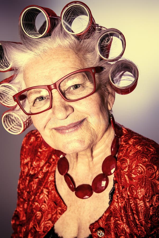 Portrait of an elderly woman in curlers looking at camera.