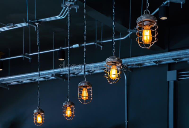 Bright orange lamps in a dark ceiling. a burning electric light bulb screwed into the socket against a dark background royalty free stock photo