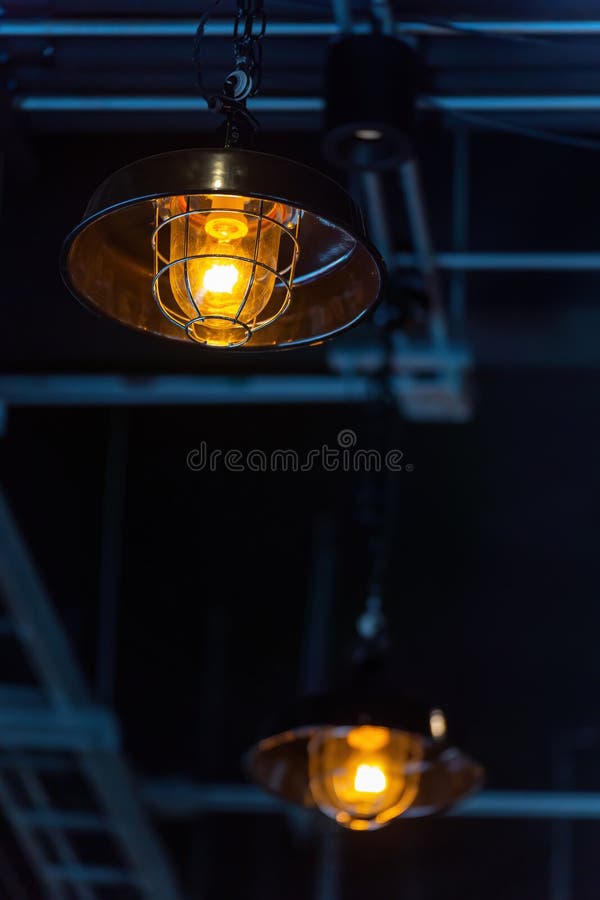 Bright orange lamps in a dark ceiling. a burning electric light bulb screwed into the socket against a dark background royalty free stock images