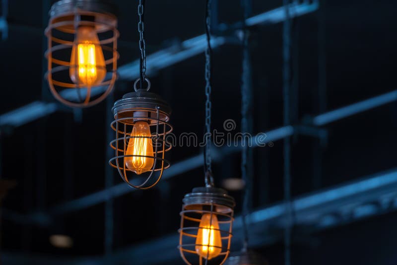 Bright orange lamps in a dark ceiling. a burning electric light bulb screwed into the socket against a dark background stock photography
