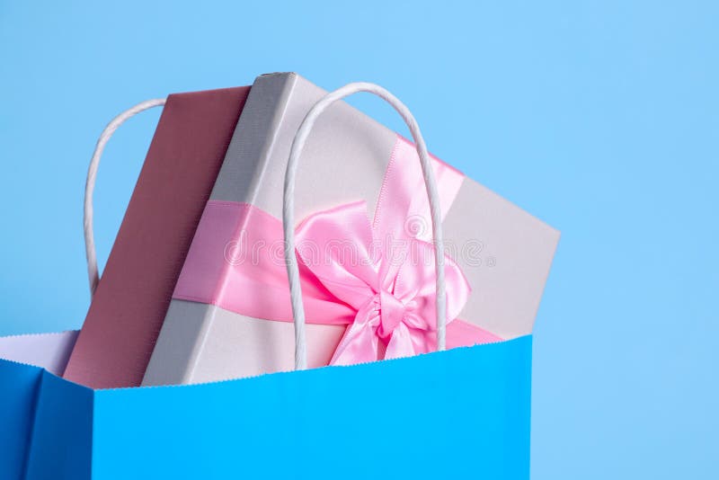 Bright Paper Shopping Bag with Gift Box on Light Blue Background