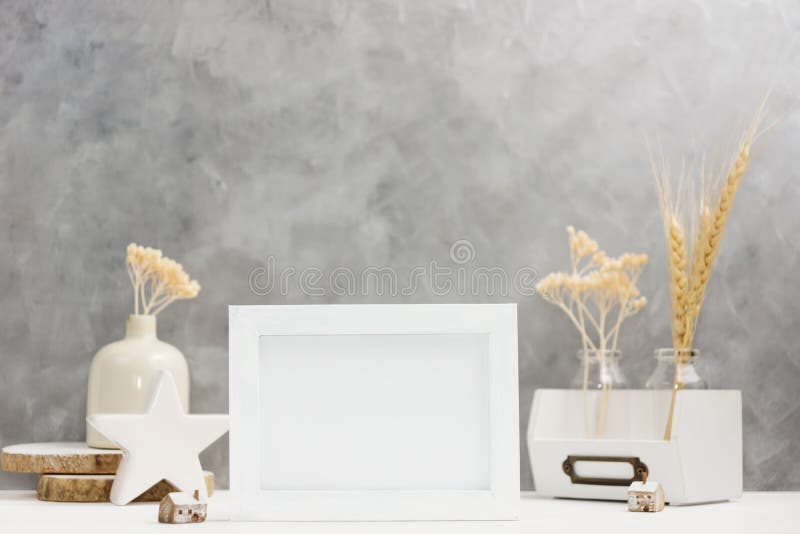 Bright Photo frame mock up with plants in vase, ceramic decor on shelf against grey wall. Scandinavian style royalty free stock photography