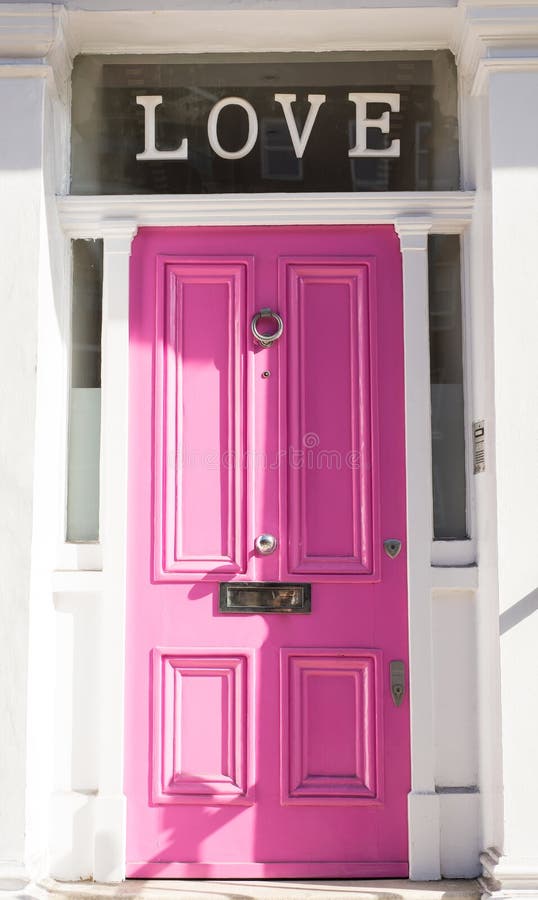 Bright pink door on a white wall with Love on top stock photography