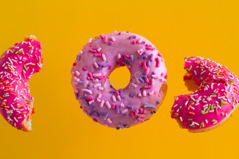 pink sweet donuts with sprinkles on vibrant yellow background royalty free stock photo pink sweet donuts with sprinkles on vibrant yellow background royalty free stock photo
