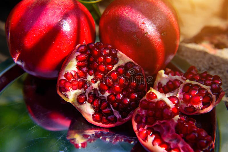 Bright pomegranates are very beautiful, tasty and healthy. Ripe garnet photo on a metal dish, very close up