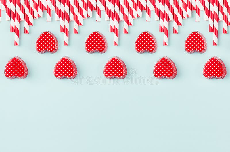 Bright red hearts and cocktail straws as decorative border on mint pastel paper background. stock image
