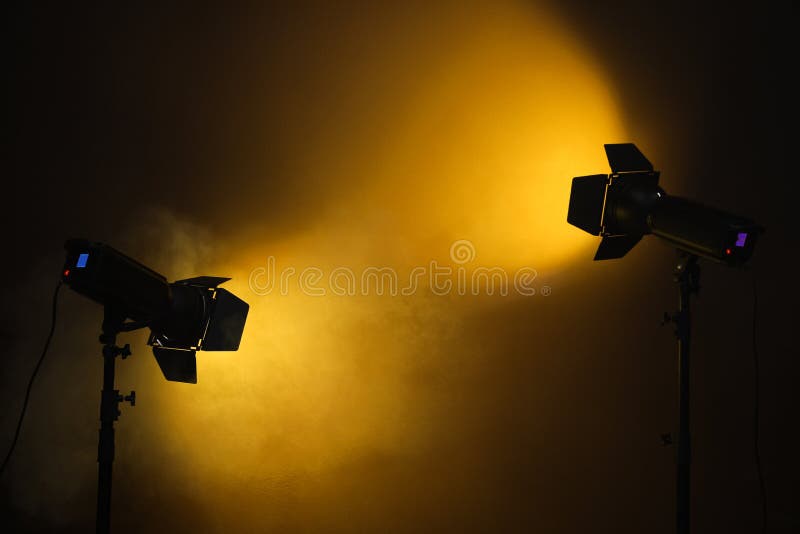 Bright Spotlights Near Wall in Dark Room, Space for Text Stock Photo