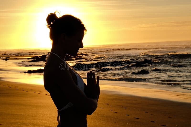 Bright sunrays behind yogi master forming silhouette stock image
