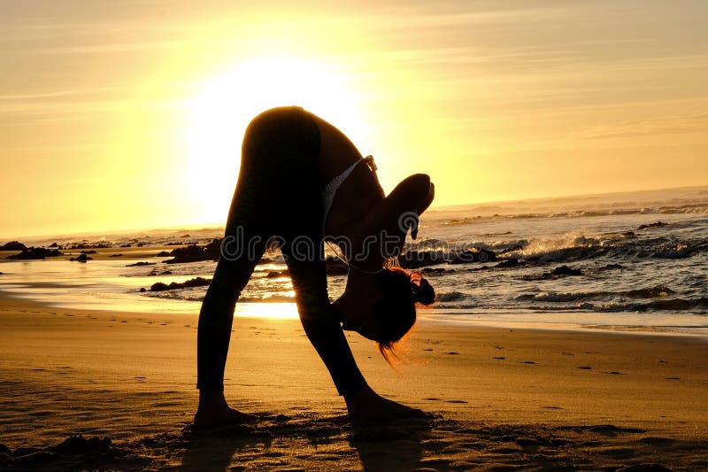 Bright sunrays behind yogi master forming silhouette royalty free stock photo