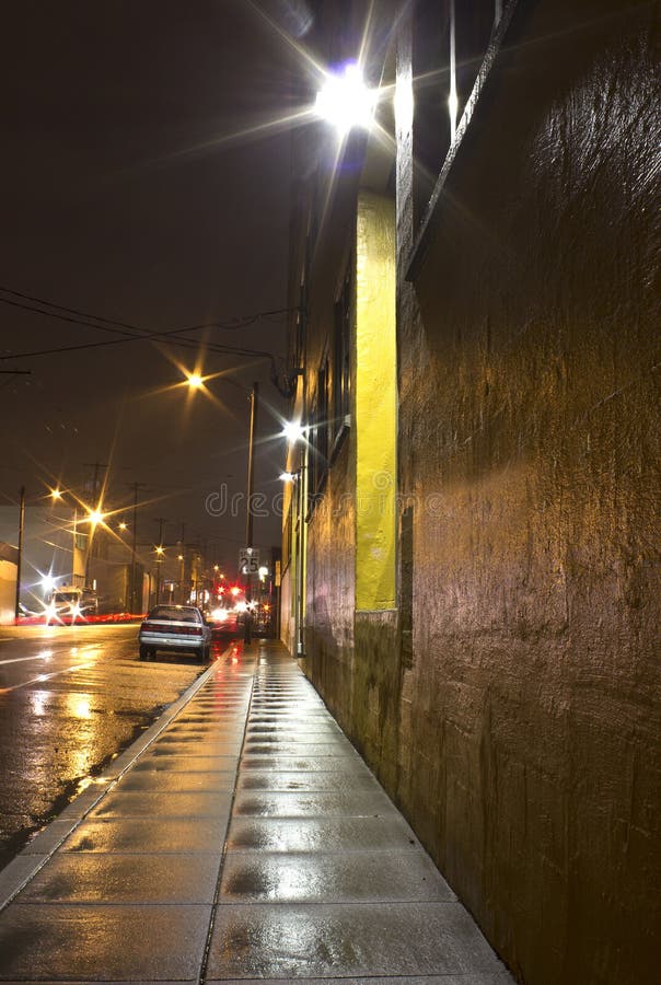 Bright Wet City Sidewalk and Street At Night. Bright wet city sidewalk and street at lit at night Bright Wet City Sidewalk and Street At Night. Bright wet city sidewalk and street at lit at night