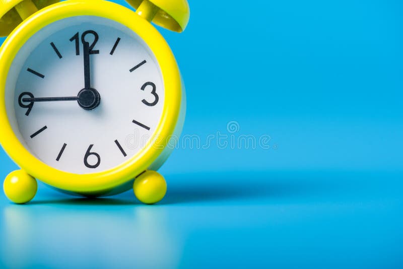 Bright Yellow Clock on Blue Background with Empty Space for Text
