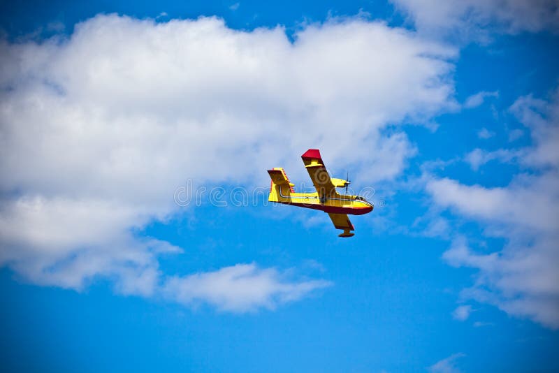 Bright Yellow Firefighter Plane in a Blue Sky stock photo