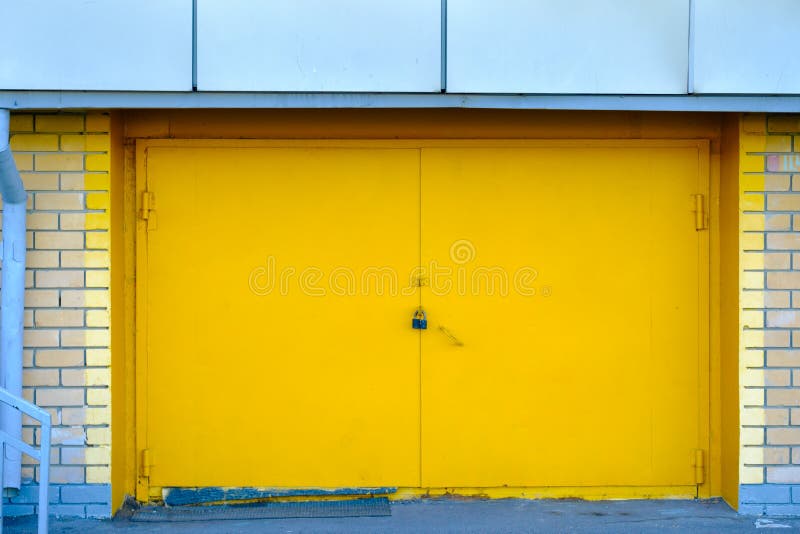 Bright Yellow Metal Door from the Garage Locked Stock Photo - Image of street, exit: 154071792