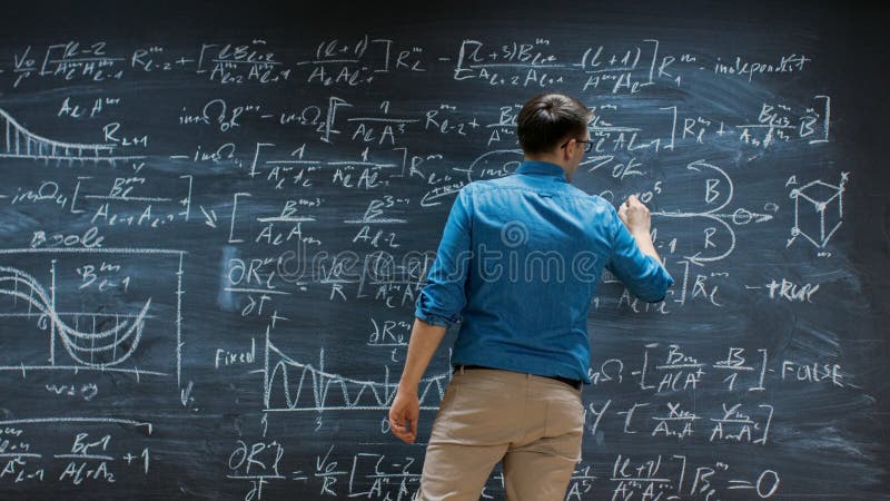 Brilliant Young Mathematician Is Writing on Big Blackboard and Thinking about Solving Long and stock photography