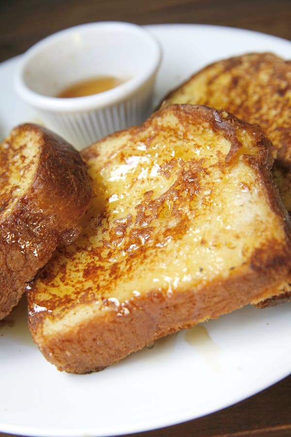 Close up macro shot of French toast & maple syrup on a plate. Close up macro shot of French toast & maple syrup on a plate