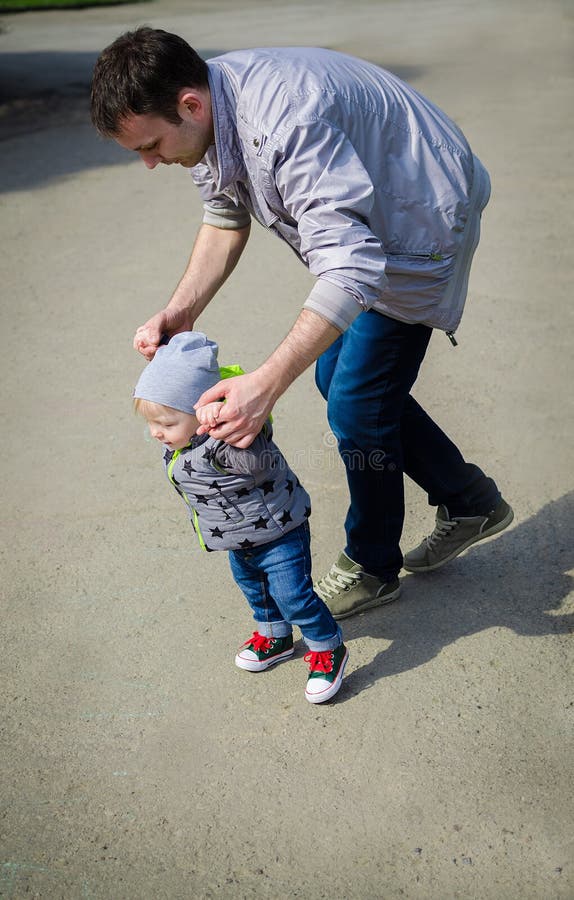 Bringen Sie das Führen seines Babys mit den ersten Schritten hervor lizenzfreie stockfotografie