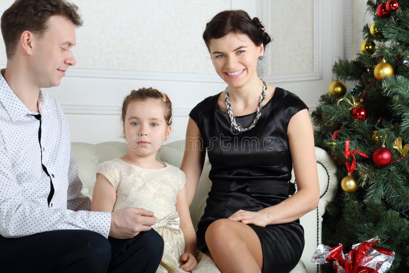 Bringen Sie, kleine Tochter hervor und lächelnde Mutter sitzen auf Sofa lizenzfreie stockfotos