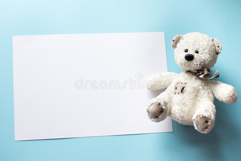 Brinquedo da criança do urso de peluche com quadro para a foto ou vale-oferta em um fundo azul pastel fotografia de stock Brinquedo da criança do urso de peluche com quadro para a foto ou vale-oferta em um fundo azul pastel fotografia de stock