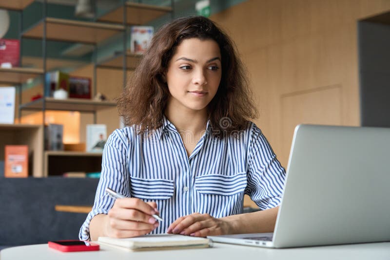 Brist på en liten flicka som använder en bärbar dator som tittar på onlineseminarium. royaltyfria foton