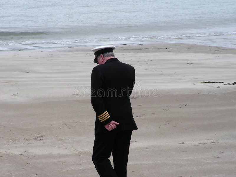 A man on a mobile phone wearing a british merchant navy uniform. A man on a mobile phone wearing a british merchant navy uniform.