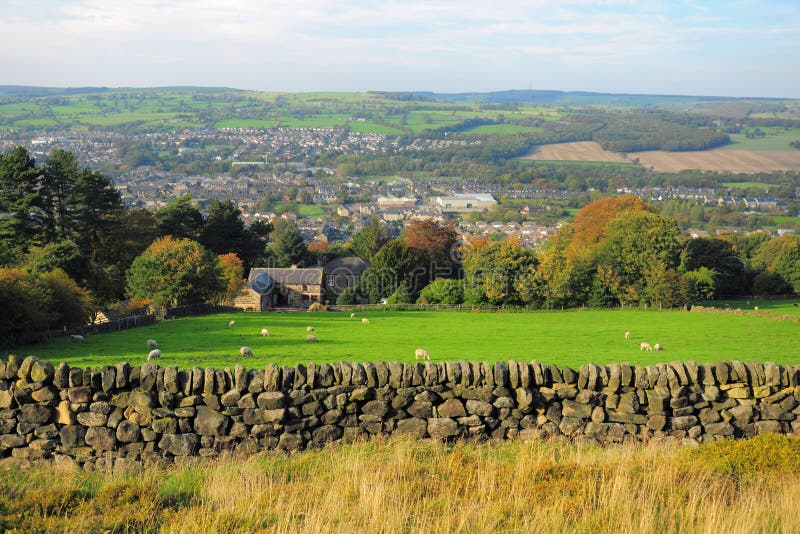 Tipici di stagione di paesaggio Inglese, Otley Yorkshire, con muro a secco di recinzione in primo piano, fattoria, pecora, alberi, città distante e chiaro orizzonte, presa nell'autunno / autunno.