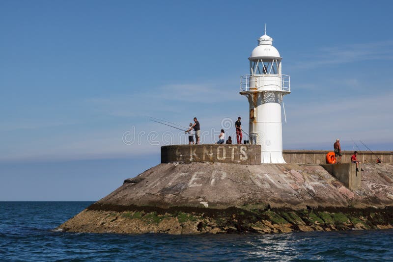 BRIXHAM, DEVON/UK - 28 JULI: Mensen die dichtbij de vuurtoren vissen royalty-vrije stock afbeelding BRIXHAM, DEVON/UK - 28 JULI: Mensen die dichtbij de vuurtoren vissen royalty-vrije stock afbeelding
