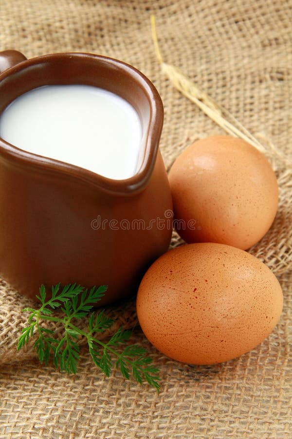 Brocca di vetro con latte e le uova immagine stock Brocca di vetro con latte e le uova immagine stock