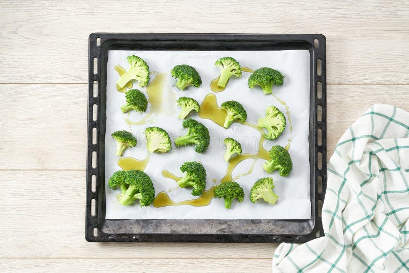 Broccoli with Olive Oil and Spice on Baking Tray, Preparation for Baking, Top View Stock Photo