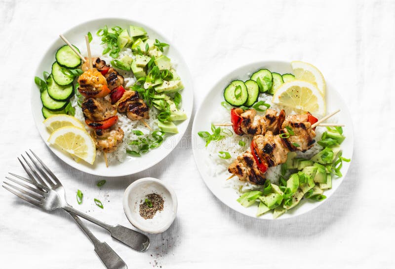 Brochettes grillées de poulet de chaux de miel de piment avec le Salsa de riz et d'avocat sur le fond clair, vue supérieure images stock Brochettes grillées de poulet de chaux de miel de piment avec le Salsa de riz et d'avocat sur le fond clair, vue supérieure images stock