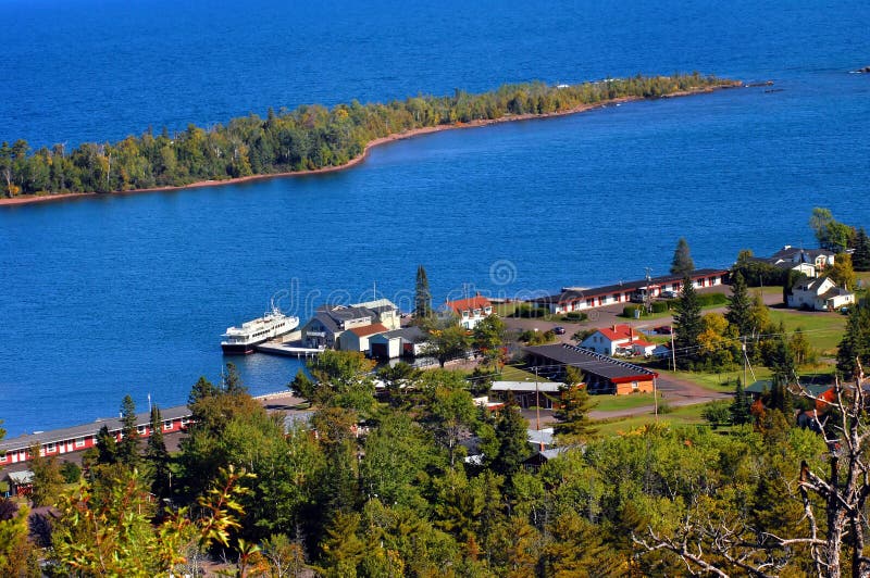 Brockway Mountain Drive overlooks the Isle Royal boat dock and surrounding buildings. Vivid blue waters of Copper Harbor and Lake Superior fill image. Brockway Mountain Drive overlooks the Isle Royal boat dock and surrounding buildings. Vivid blue waters of Copper Harbor and Lake Superior fill image.