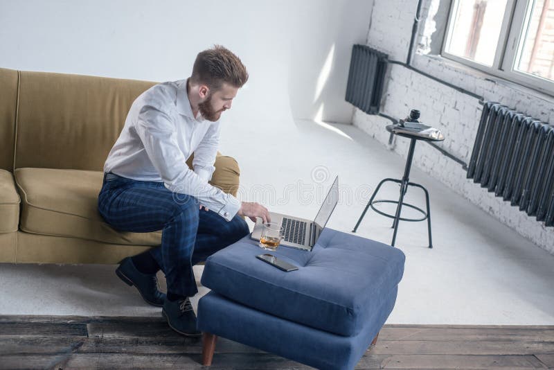 Brodatej modniś chłopiec fachowi freelance ogólnospołeczni środki zadawalają pisarskiego keyboarding na laptopie podczas gdy sied fotografia royalty free Brodatej modniś chłopiec fachowi freelance ogólnospołeczni środki zadawalają pisarskiego keyboarding na laptopie podczas gdy sied fotografia royalty free