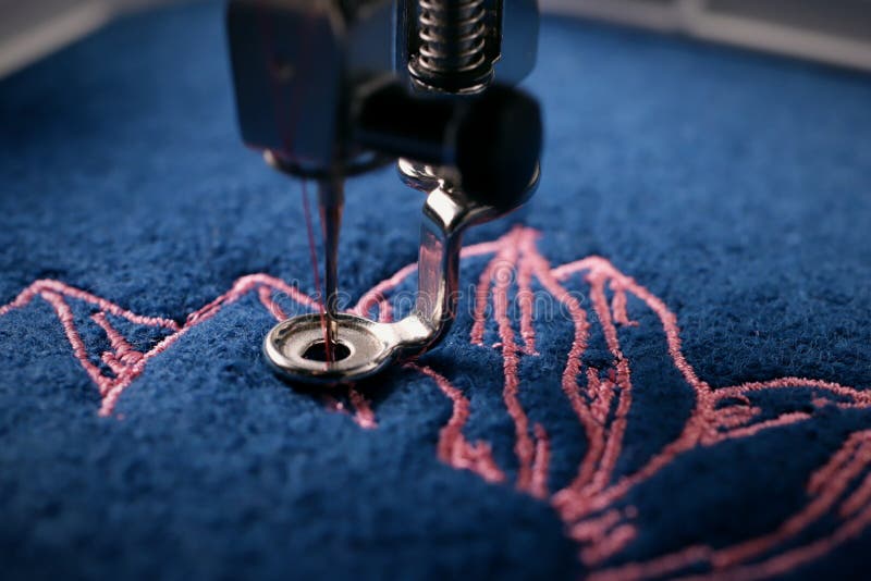 Broderier av en ljusrosa magnolia på klassisk blå kokt ull och nål, fot och nålskydd på broderier arkivfoton Broderier av en ljusrosa magnolia på klassisk blå kokt ull och nål, fot och nålskydd på broderier arkivfoton