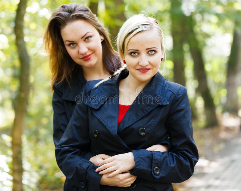 Beautiful fraternal twins in a park hugging each other. Beautiful fraternal twins in a park hugging each other.