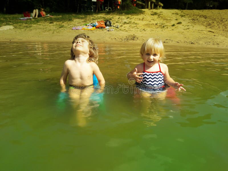 Broer en zuster het ontspannen op stoelen in een water stock fotografie Broer en zuster het ontspannen op stoelen in een water stock fotografie