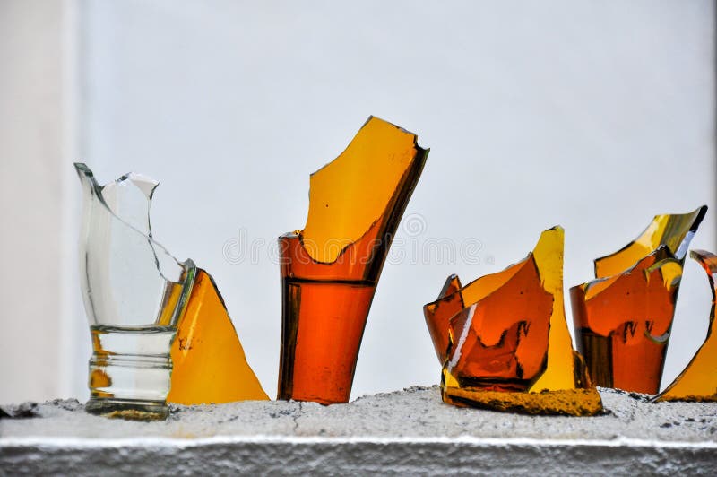 Broken bottles glass on top of fence wall.