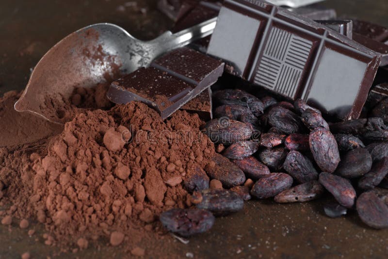 Broken dark chocolate and cocoa beans on a stone table broken dark chocolate and cocoa beans on a stone table close up stock afbeelding