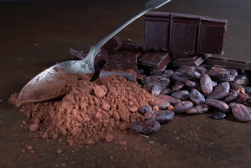 Broken dark chocolate and cocoa beans on a stone table close up broken dark chocolate and cocoa beans on a stone table royalty-vrije stock afbeelding